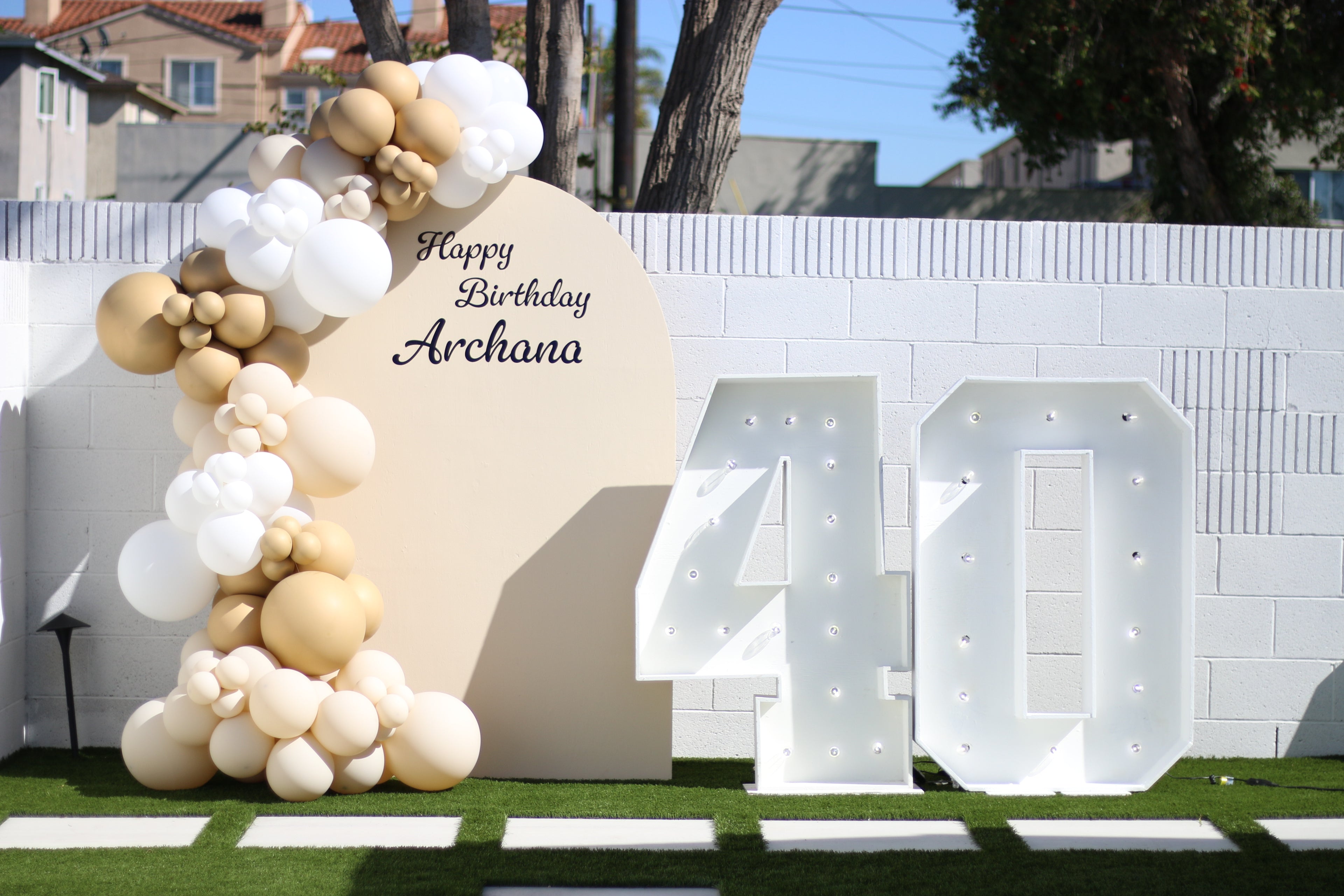 Balloon arch backdrop with custom vinyl sign for photos